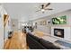 Open-concept living room with hardwood floors, fireplace, and modern ceiling fan at 4511 Perry St, Denver, CO 80212