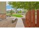 Beautifully landscaped backyard with a stone patio, picnic table, and manicured lawn surrounded by a white fence at 2605 Gray Wolf Loop, Broomfield, CO 80023