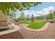 Spacious backyard with stone patio, wooden picnic table, and lush green lawn enclosed by a white fence at 2605 Gray Wolf Loop, Broomfield, CO 80023