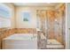 A luxurious soaking tub next to a glass shower with tile surround and a window at 2605 Gray Wolf Loop, Broomfield, CO 80023