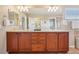 A wooden vanity with double sinks and ample counter space in a well-lit bathroom at 2605 Gray Wolf Loop, Broomfield, CO 80023