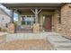 Inviting front porch with stone pillars, seating, and a view of the landscaped front yard at 2605 Gray Wolf Loop, Broomfield, CO 80023