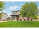 Charming two-story home with a lush green lawn, stone accents, and a welcoming front porch at 2605 Gray Wolf Loop, Broomfield, CO 80023