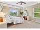 Light-filled main bedroom with a four-poster bed, tray ceilings, and bright windows at 2605 Gray Wolf Loop, Broomfield, CO 80023