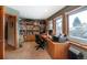 Sun-lit home office with built-in bookshelves, a large desk, and carpet floors at 2624 Kalmia Ave, Boulder, CO 80304