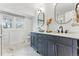 Bright bathroom featuring double vanity with marble countertop, hexagon tile floor, and updated fixtures at 2011 S Gray Dr, Lakewood, CO 80227