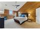 Cozy bedroom with wood paneling, plush carpeting, and a comfortable bed with blue accents at 2011 S Gray Dr, Lakewood, CO 80227