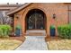 Welcoming front entrance featuring a brick archway, elegant lighting, and well-maintained landscaping at 2011 S Gray Dr, Lakewood, CO 80227