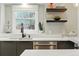 Modern kitchen with stainless steel dishwasher, sleek white countertops, and black shelving at 2011 S Gray Dr, Lakewood, CO 80227
