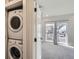 A modern bedroom with stackable washer and dryer, plus balcony access and ample light at 1462 Yates St, Denver, CO 80204