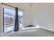 A bright bedroom with gray carpet and access to the balcony overlooking the surrounding neighborhood at 1462 Yates St, Denver, CO 80204