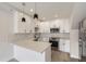 Bright kitchen with white cabinets, marble countertops, stainless steel appliances, and modern pendant lighting at 1462 Yates St, Denver, CO 80204