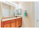 Well-lit bathroom with a large mirror, wooden vanity, and neutral walls and countertops at 22920 E Roxbury Dr # H, Aurora, CO 80016