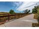 A paved community trail is pictured with an iron fence and trees at 22920 E Roxbury Dr # H, Aurora, CO 80016