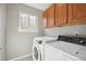 Well-lit laundry room with wood cabinets, washer and dryer hookups, and a window at 3982 S Himalaya Way, Aurora, CO 80013