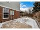 Exterior view highlighting brickwork, a covered patio, and a serene backyard setting, offering a peaceful retreat at 7501 S Ivanhoe Cir, Centennial, CO 80112