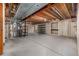 Unfinished basement with exposed beams, concrete walls, and floor, offering potential for customization and additional living space at 7501 S Ivanhoe Cir, Centennial, CO 80112