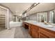 Spacious bathroom featuring a long vanity with dual sinks, soaking tub, walk in closet, and shower at 7501 S Ivanhoe Cir, Centennial, CO 80112