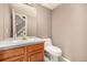 Well-maintained half-bathroom featuring a wood vanity and updated fixtures, conveniently located near the stairs at 7501 S Ivanhoe Cir, Centennial, CO 80112