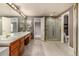 Bathroom featuring a long vanity with dual sinks, walk in closet, and gold shower at 7501 S Ivanhoe Cir, Centennial, CO 80112