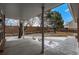 Covered patio offering a tranquil view of the landscaped backyard with mature trees and a private fence, ideal for relaxation at 7501 S Ivanhoe Cir, Centennial, CO 80112