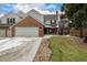 Charming two-story home featuring a brick facade, attached garage, and well-maintained lawn with mature trees at 7501 S Ivanhoe Cir, Centennial, CO 80112