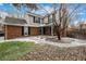 Two-story home featuring a brick and gray facade and a landscaped front yard with a beautiful tree at 7501 S Ivanhoe Cir, Centennial, CO 80112