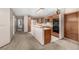 Spacious kitchen area with a central island, oak cabinets, and carpeted flooring throughout at 7501 S Ivanhoe Cir, Centennial, CO 80112