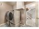 A modern laundry room featuring a front-load washer and dryer with patterned tile floors, blending functionality with style at 7501 S Ivanhoe Cir, Centennial, CO 80112