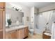 Bright bathroom featuring a shower-tub combo, light wood cabinets and light tile flooring at 9307 Amison Cir # 202, Parker, CO 80134