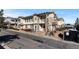Exterior of a tan condo with nice stone columns, trim, and landscaping at 9307 Amison Cir # 202, Parker, CO 80134