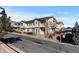 Exterior of a tan condo with nice stone columns, trim, and landscaping at 9307 Amison Cir # 202, Parker, CO 80134