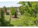 Lush backyard featuring mature trees, green grass, and distant houses overlooking the landscape at 5631 Silver Bluff Ct, Parker, CO 80134