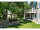 Lush backyard featuring a stone retaining wall with flower beds and a view of the upper-level balcony at 5631 Silver Bluff Ct, Parker, CO 80134