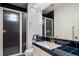 Bathroom with dark blue tile, white cabinetry, a shower and gold fixtures at 5631 Silver Bluff Ct, Parker, CO 80134