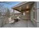 Covered deck with cozy seating around a gas fire pit, bench seating, and outdoor lighting at 5631 Silver Bluff Ct, Parker, CO 80134