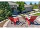 Inviting outdoor fire pit area with red Adirondack chairs and beautiful landscaping at 5631 Silver Bluff Ct, Parker, CO 80134