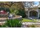 Inviting front entrance with stone walkway, manicured landscaping, mature trees, and a charming red Adirondack chair at 5631 Silver Bluff Ct, Parker, CO 80134