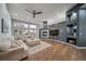 Spacious living room with hardwood floors, a modern fireplace, and large windows for natural light at 5631 Silver Bluff Ct, Parker, CO 80134