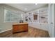 Home office with custom built-in shelving, wood floors, and a large bright window at 5631 Silver Bluff Ct, Parker, CO 80134