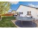 Expansive backyard featuring a well-maintained lawn, trampoline, and a patio with outdoor furniture, ideal for entertaining at 410 Clover Ct, Frederick, CO 80530