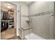 Tiled walk-in shower with a corner seat next to a large open walk-in closet space at 410 Clover Ct, Frederick, CO 80530