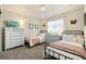 Bright bedroom with two twin beds, charming decor, and plenty of natural light at 410 Clover Ct, Frederick, CO 80530