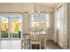 Bright dining area with wood floors, white table and chairs, with sliding glass door to the backyard at 410 Clover Ct, Frederick, CO 80530