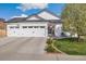 Charming single-story home featuring a three-car garage, manicured lawn, and American flag at 410 Clover Ct, Frederick, CO 80530