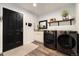 Modern laundry room with dark front-loading machines, storage, and stylish decor at 410 Clover Ct, Frederick, CO 80530