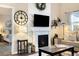 Living room with a fireplace, TV, decorative clock, and open doorway to the main bedroom at 410 Clover Ct, Frederick, CO 80530