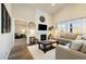 A modern living room with a fireplace, TV, comfortable seating, and ample natural light at 410 Clover Ct, Frederick, CO 80530