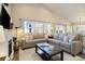 A living area features a sectional couch, fireplace and windows with views to the back yard at 410 Clover Ct, Frederick, CO 80530