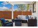 Cozy covered patio with wicker furniture, string lights, and a fire pit, perfect for outdoor relaxation at 410 Clover Ct, Frederick, CO 80530